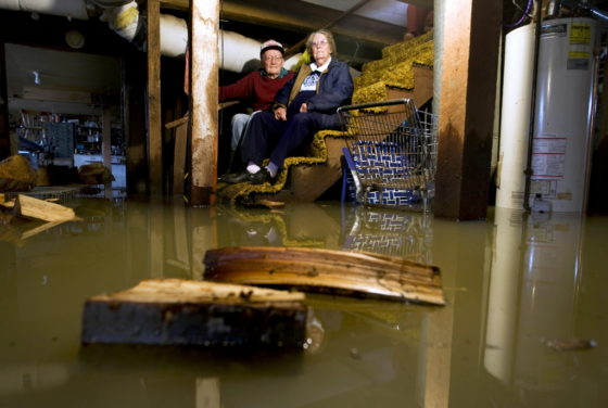 2 people on steps of flooded-basement